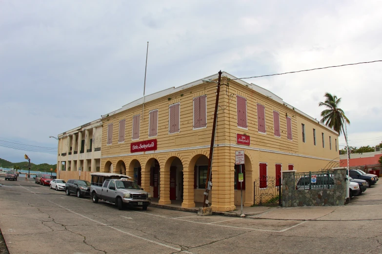 an old fashioned building with several cars parked outside