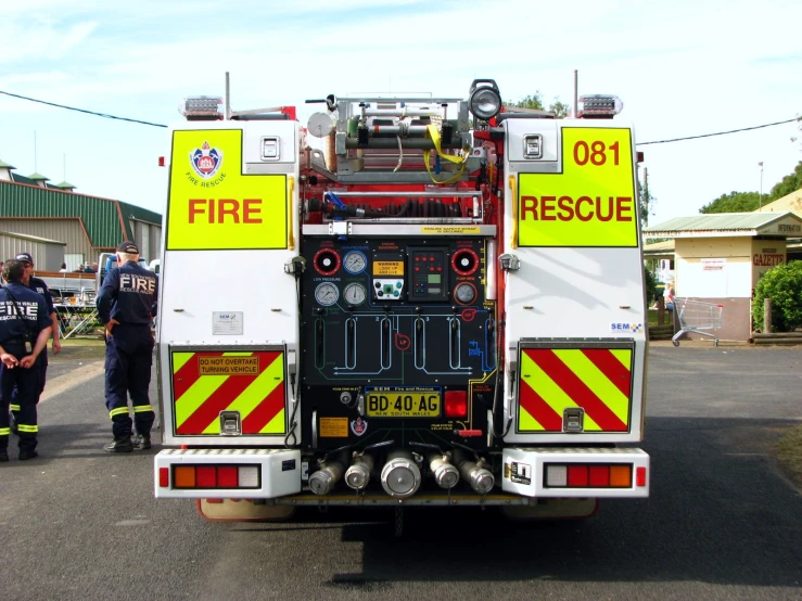 two men with fire trucks standing in front of some houses