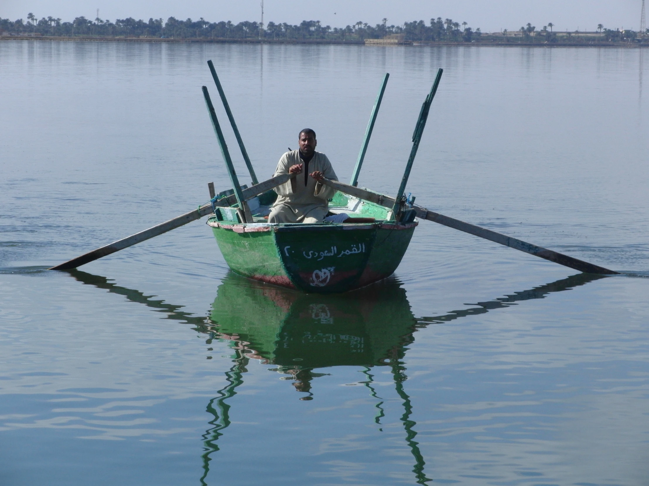 a man sitting in a green and black boat