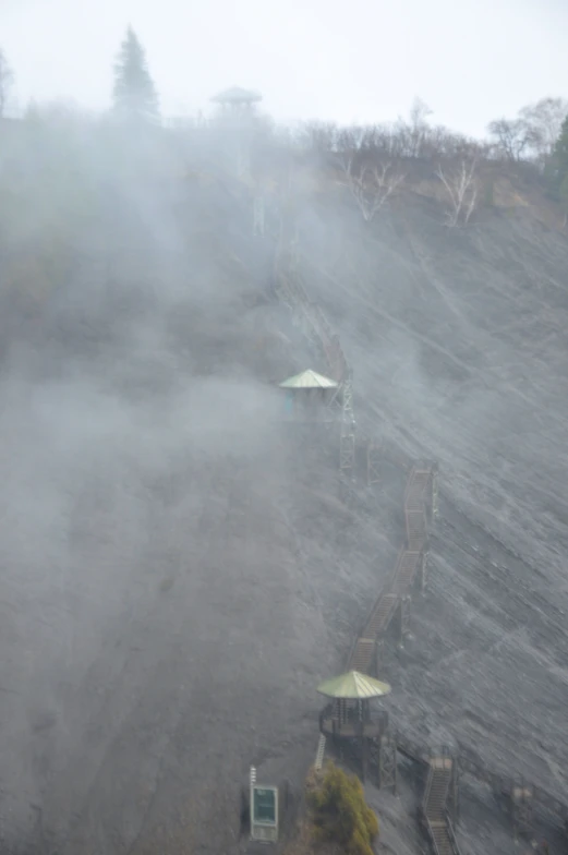 several umbrellas and steps in the fog on a hill