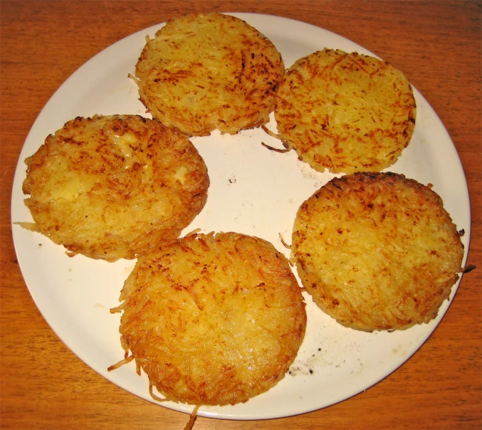 three fried tater tots on a white plate on a table