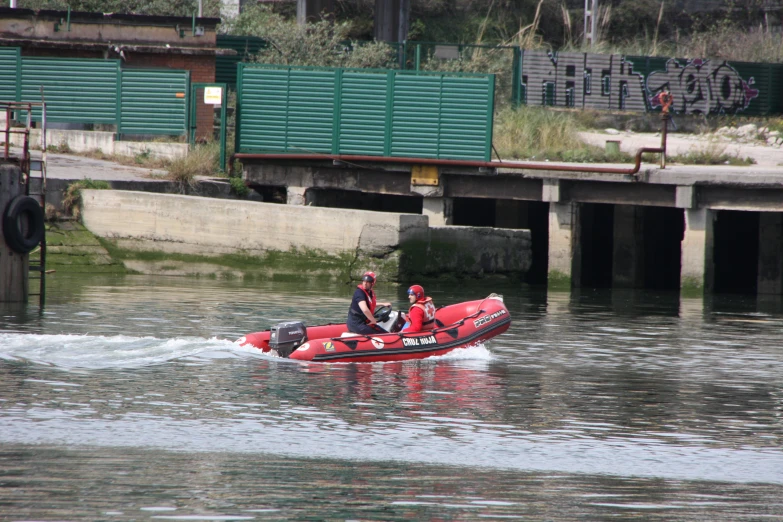 a small boat with two men riding in the water