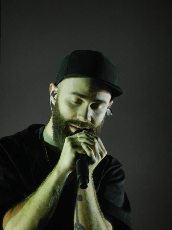 man with piercings and beard taking a microphone in his mouth