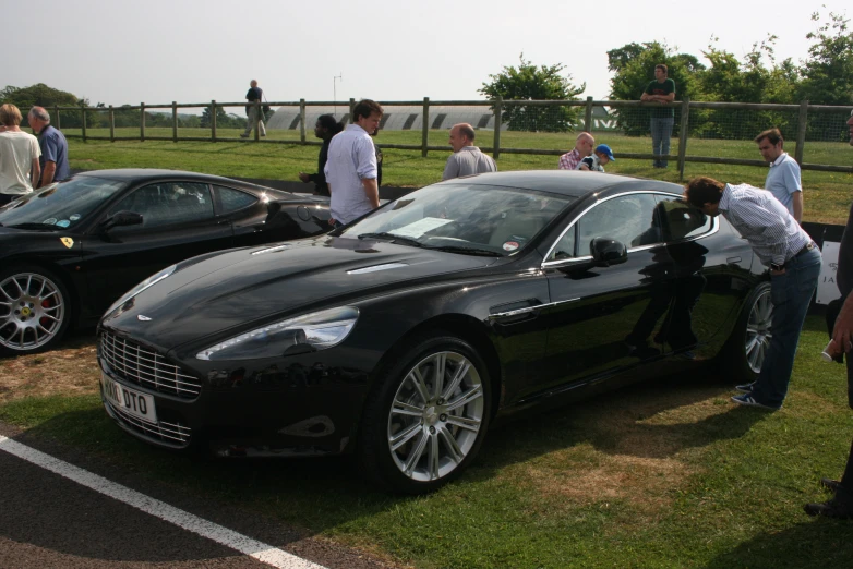 a black car is sitting in front of some other cars