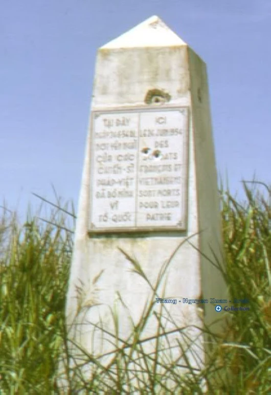 a cement monument stands in a field of grass