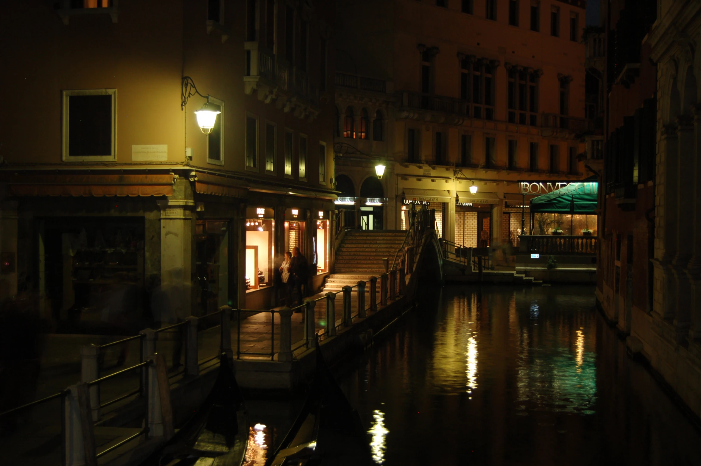 the building beside the river is lit up at night