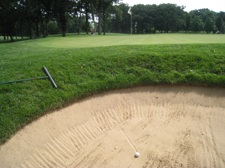 a golf green and dirt course with some tee ball on it