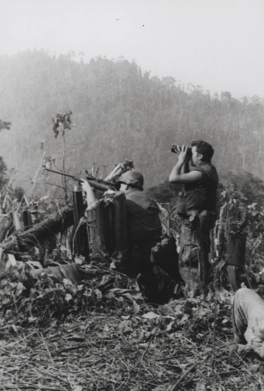 two men are taking pictures while standing in front of a truck that has been destroyed