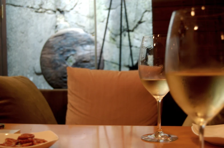 two wine glasses next to each other sitting on a table