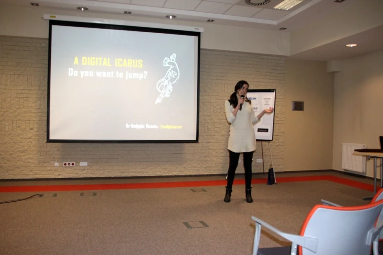 a woman in white is giving a lecture