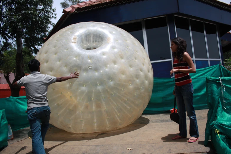a man and woman unpacking a large bubble ball