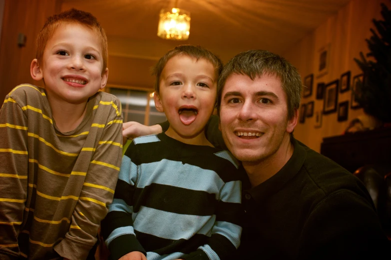 three smiling s and one older boy posing for a pograph