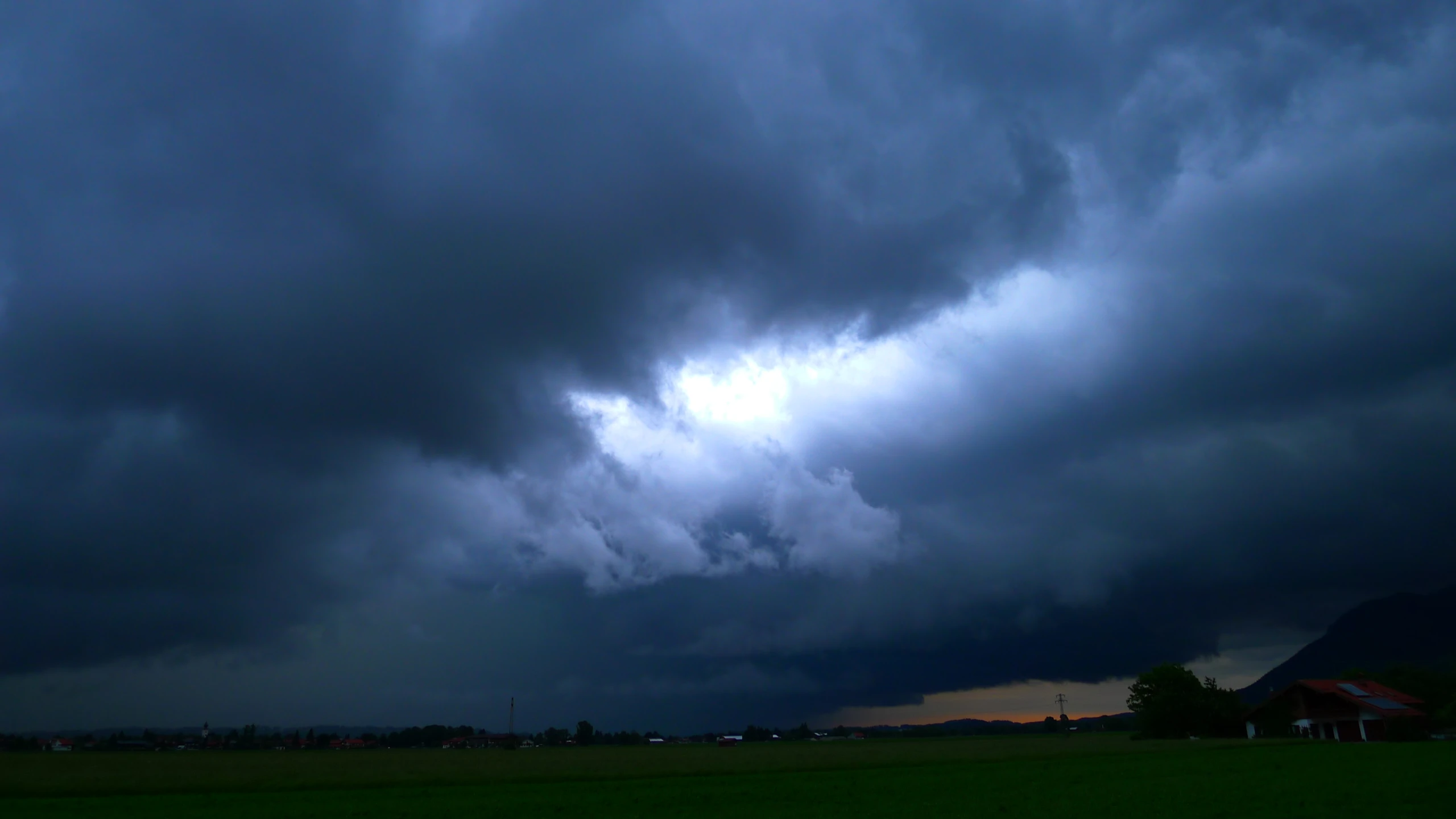 the sky is very dark and cloudy as it begins to glow green