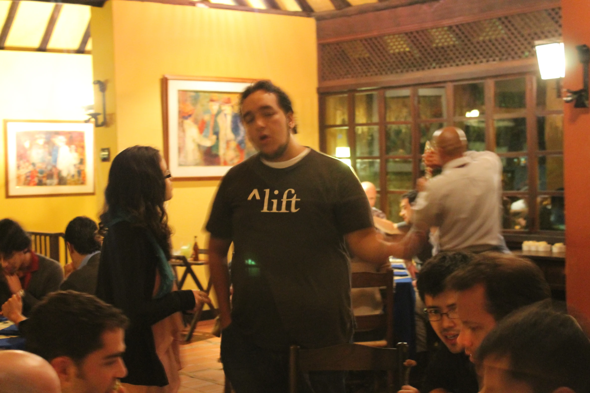 several people in a restaurant with the people sitting