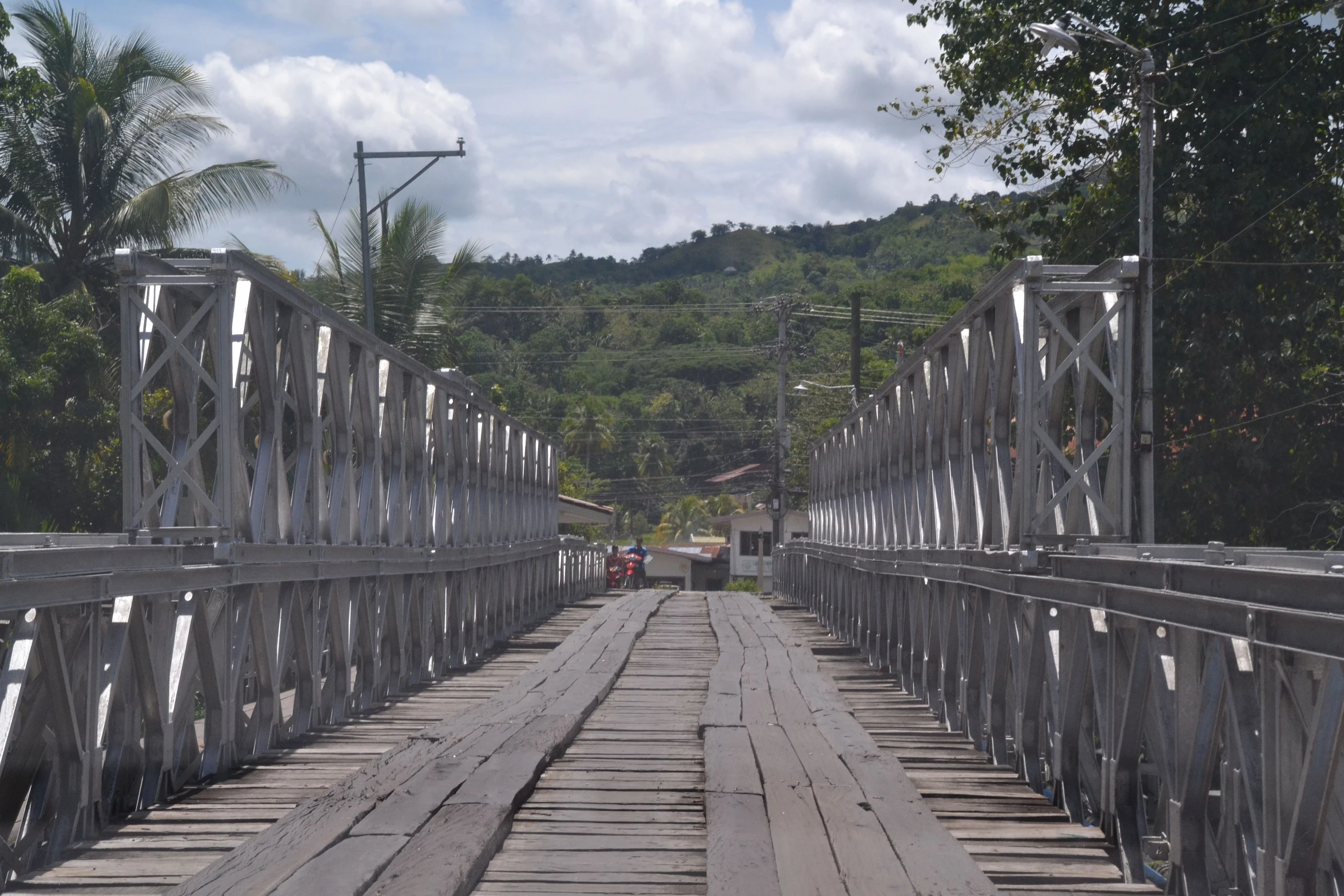 people walking across a bridge over water