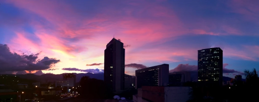 pink, blue and purple clouds at twilight over a city