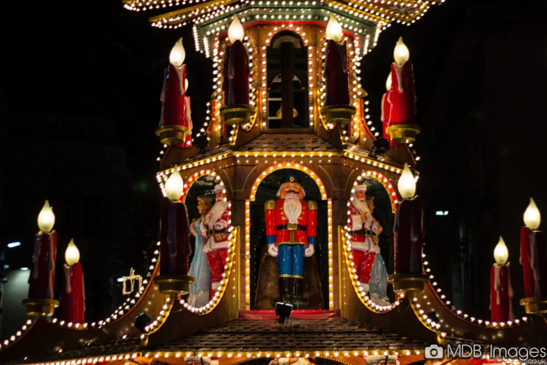 lighted clock tower with santa figurines and lights at night