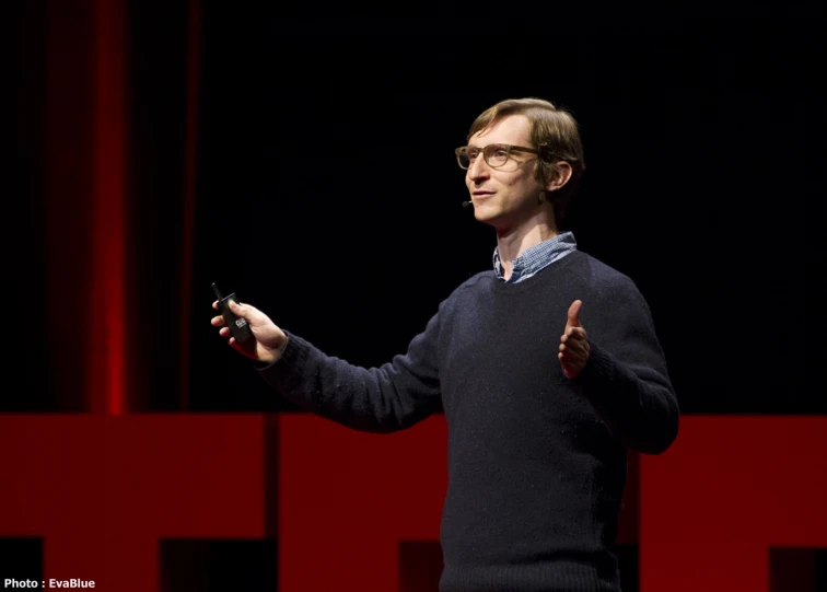 man on stage giving a presentation with his thumb