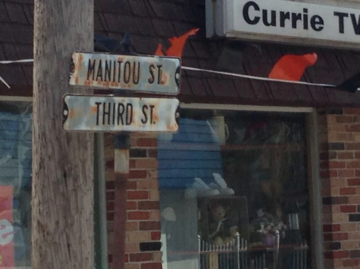 two signs are displayed next to an old wooden pole