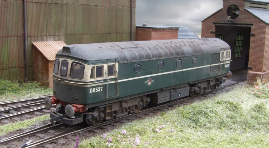 an old train sitting by a shed on tracks