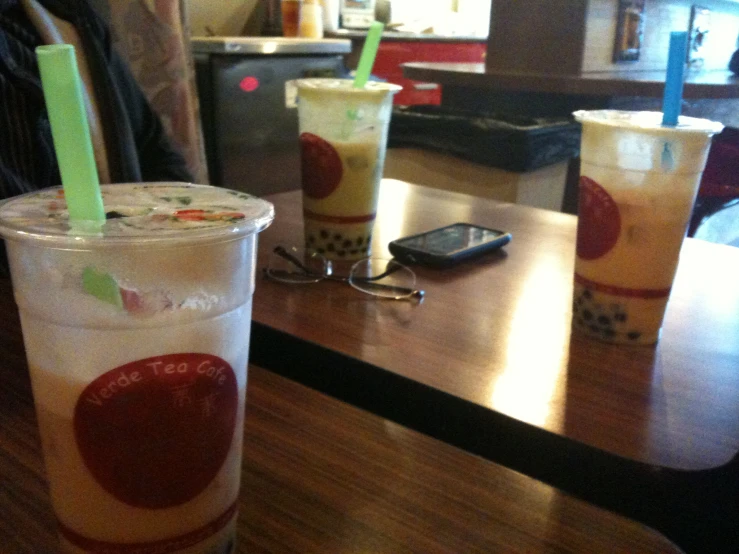 a table topped with drinks sitting on top of a wooden table