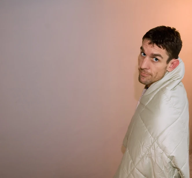 a man in a white coat looks forward while standing