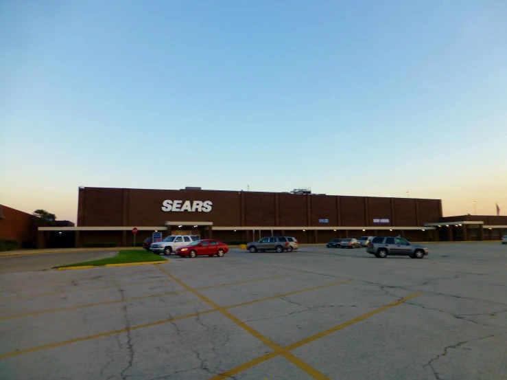 a parking lot outside a sears's store with cars parked in it