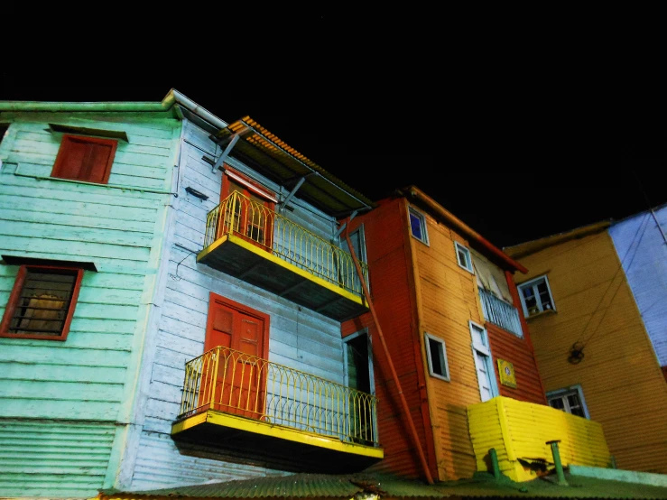 brightly painted houses on the street at night