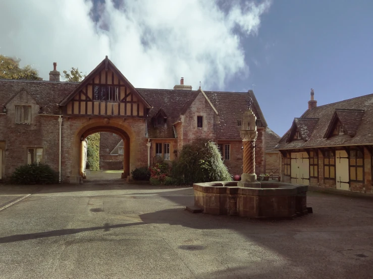 the entrance of the building has a stone fountain in front