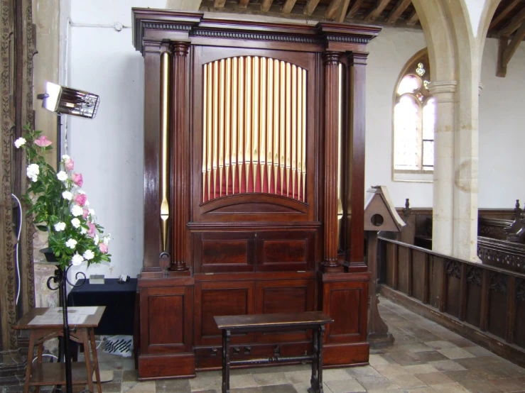 a big wooden music organ in the corner of a room