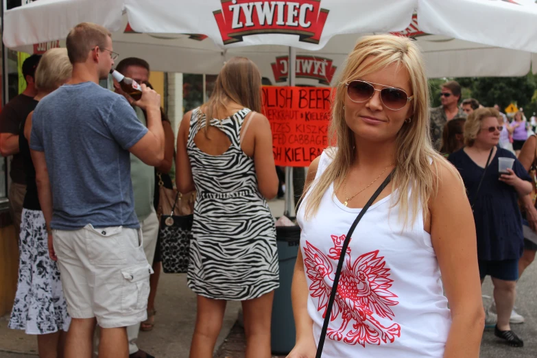 a lady standing in front of a stand with red and white signs