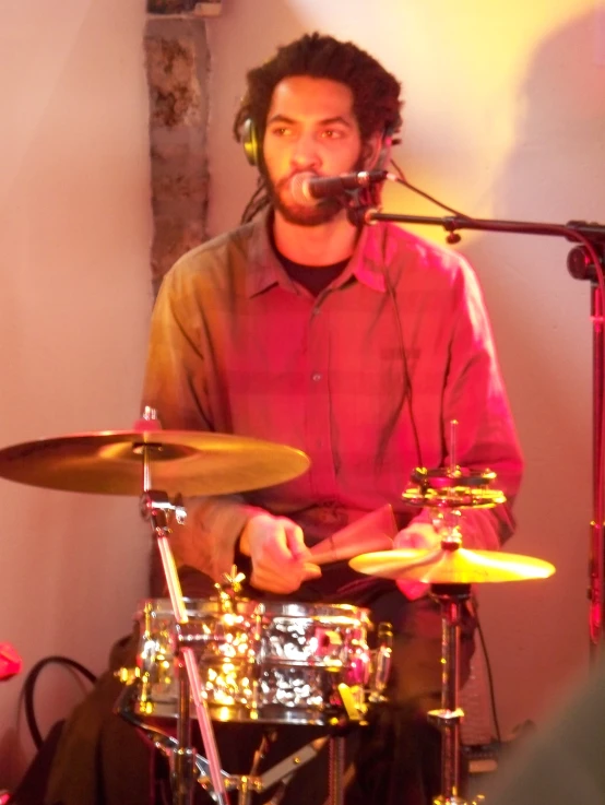 a man playing drums and a microphone behind him