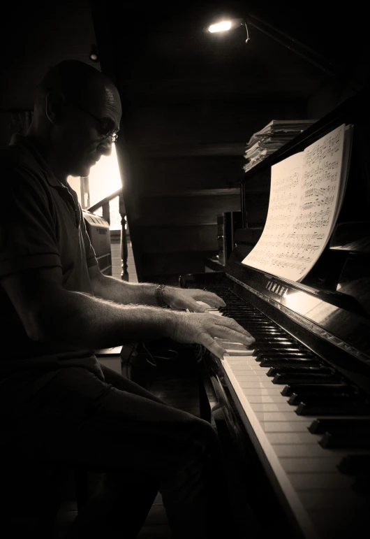 a man playing a piano in black and white