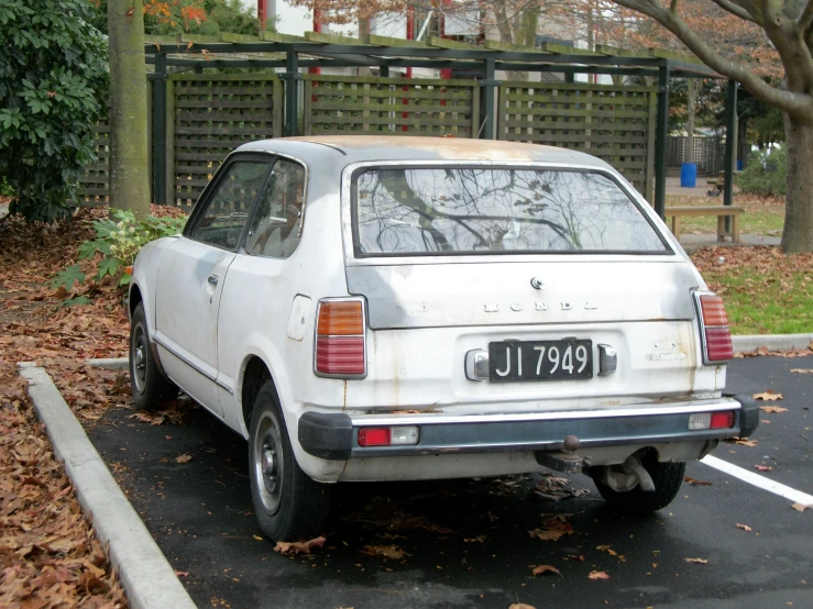 an old white car parked on the street