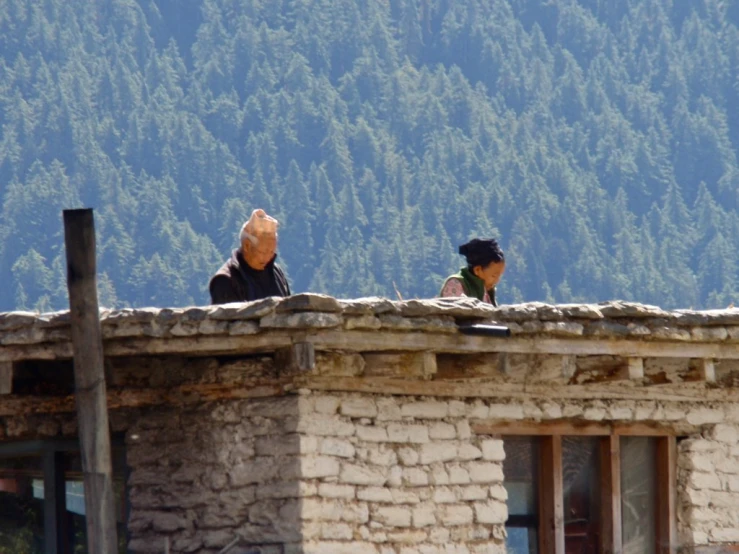 two people are looking off the roof of a building