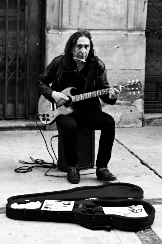 a person sitting on top of a suitcase with an electric guitar