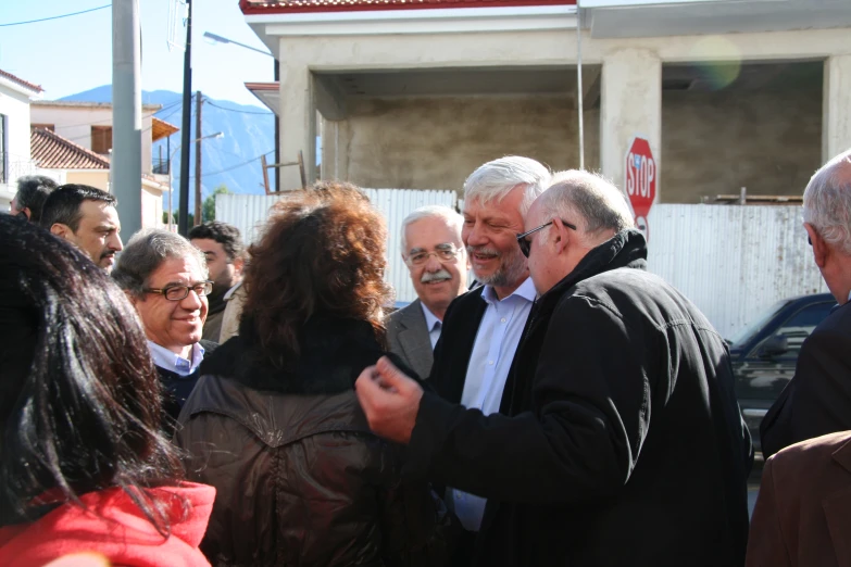 several people standing outside on the street near a building