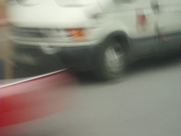 a blurry view of a white van and a red handle