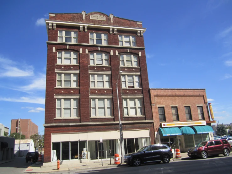 a very tall brick building sitting on the corner of a street