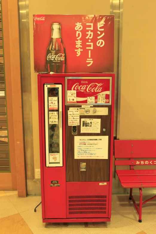 an old coca - cola machine with coke in front