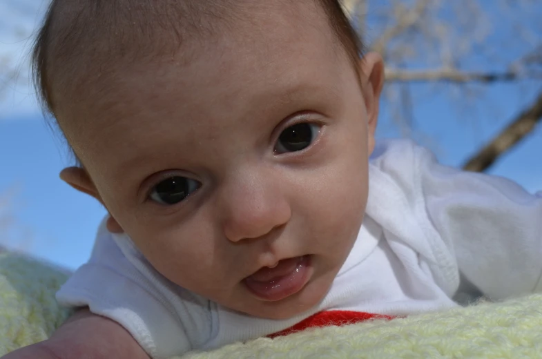 a baby is laying on a blanket staring at the camera