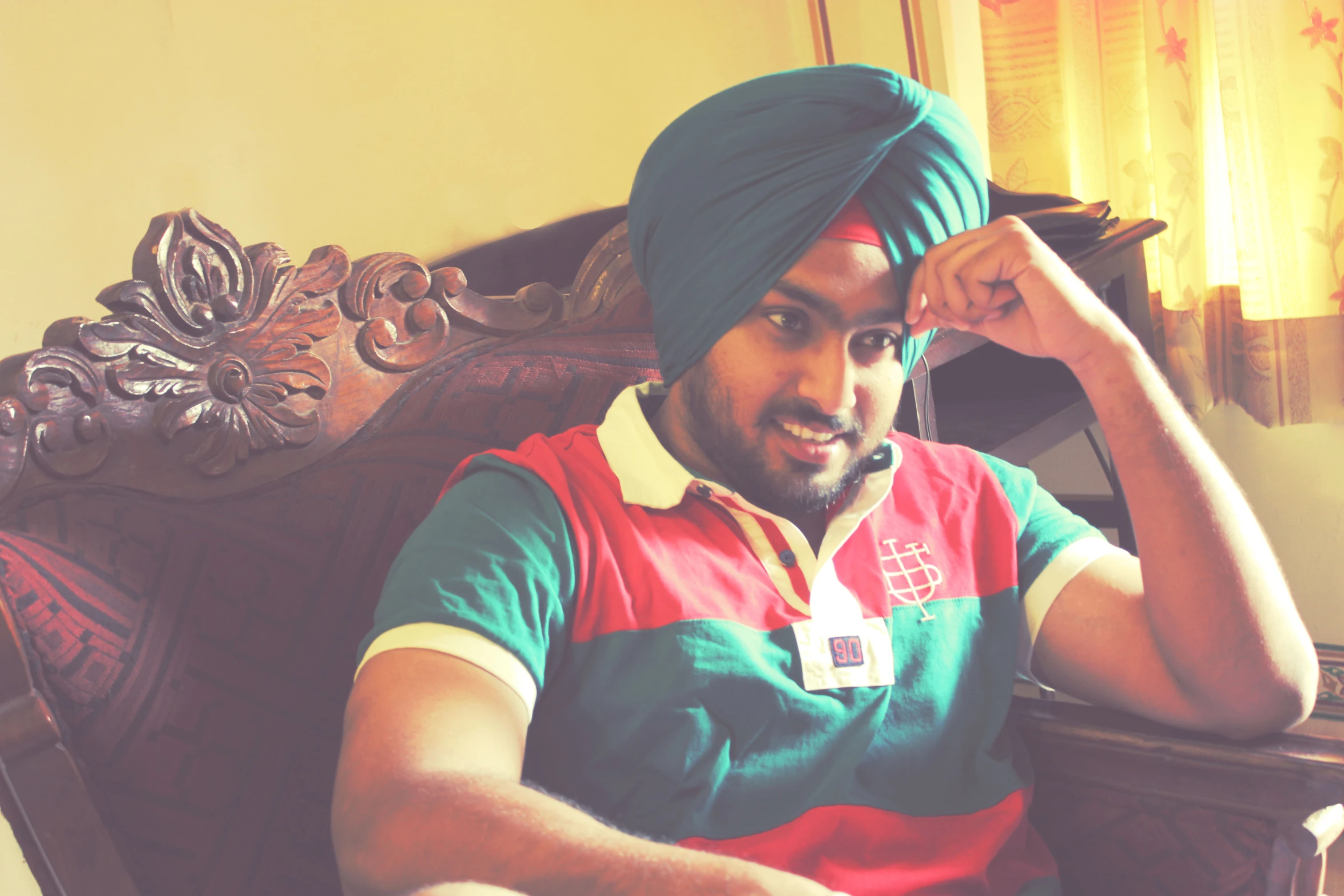 a man sitting in a chair wearing a green turban