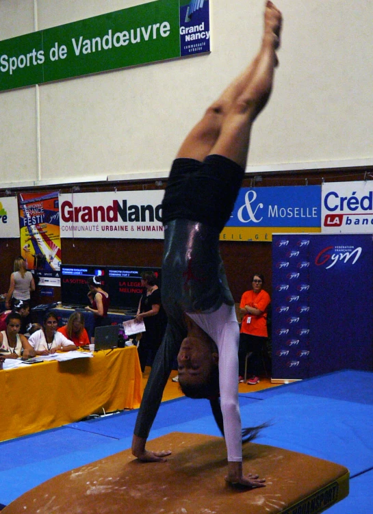a person is doing a handstand on a beam
