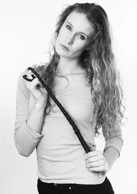 black and white pograph of girl with long hair holding a cross