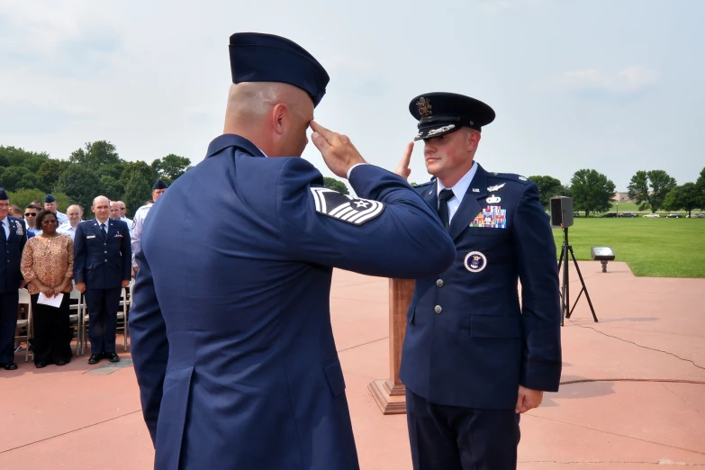 two people in uniforms are saluting others