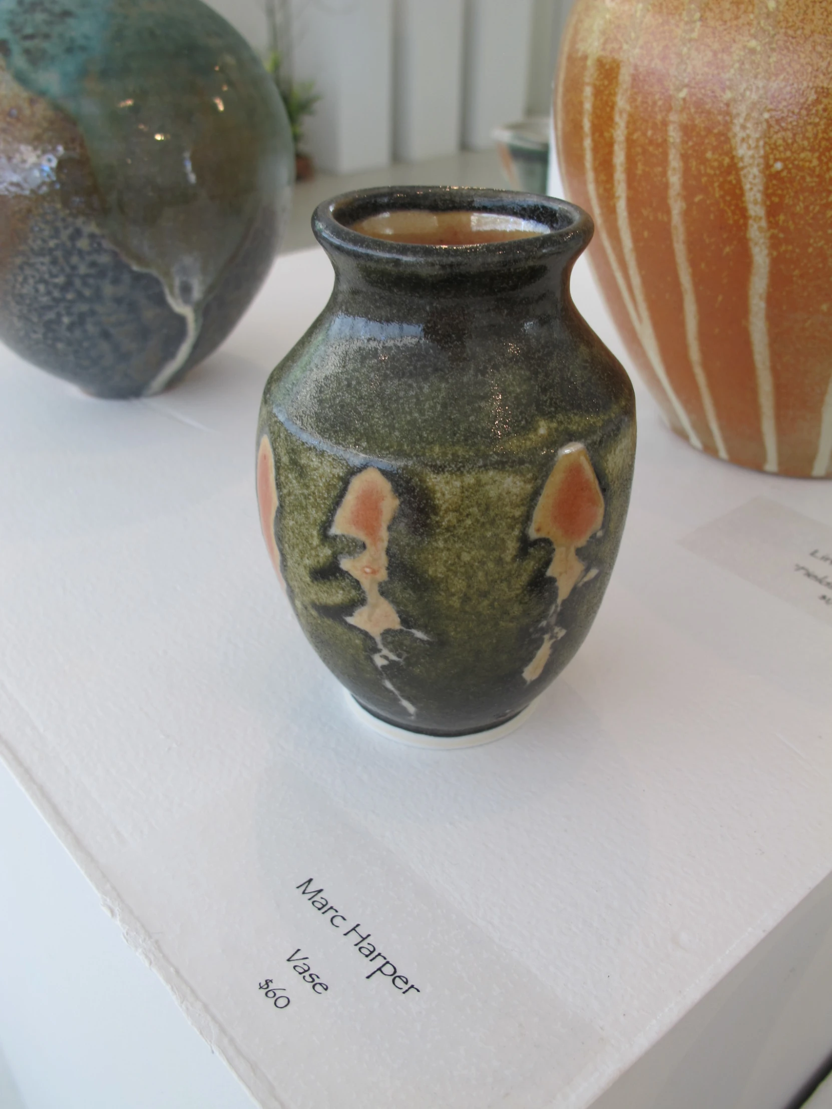 two vases with artistic designs are on display