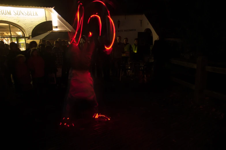 person spinning red lights on a rope over their head