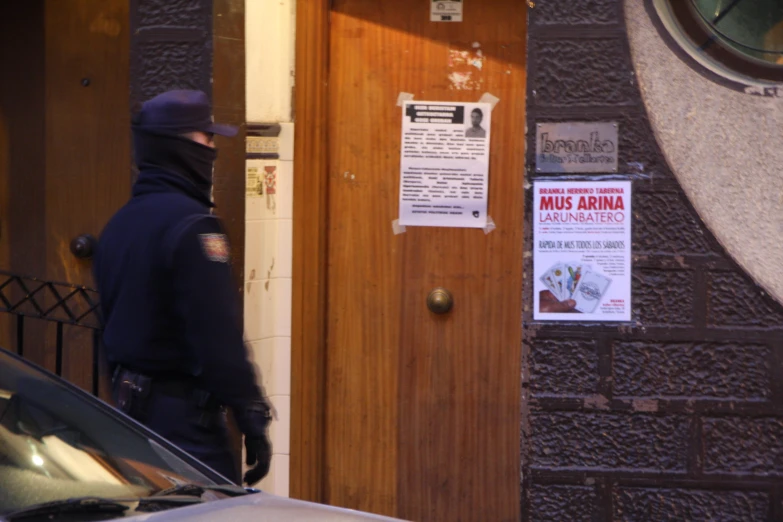 a police officer standing next to a door of a building