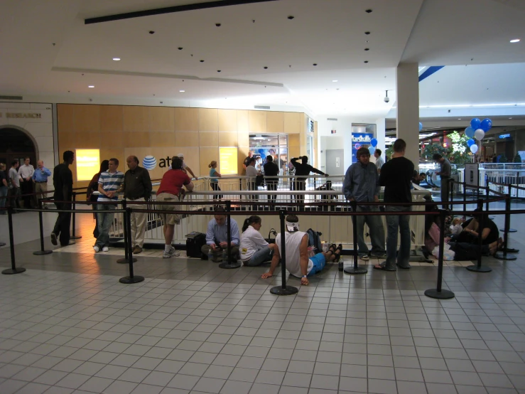 people standing and sitting on the ground in a building
