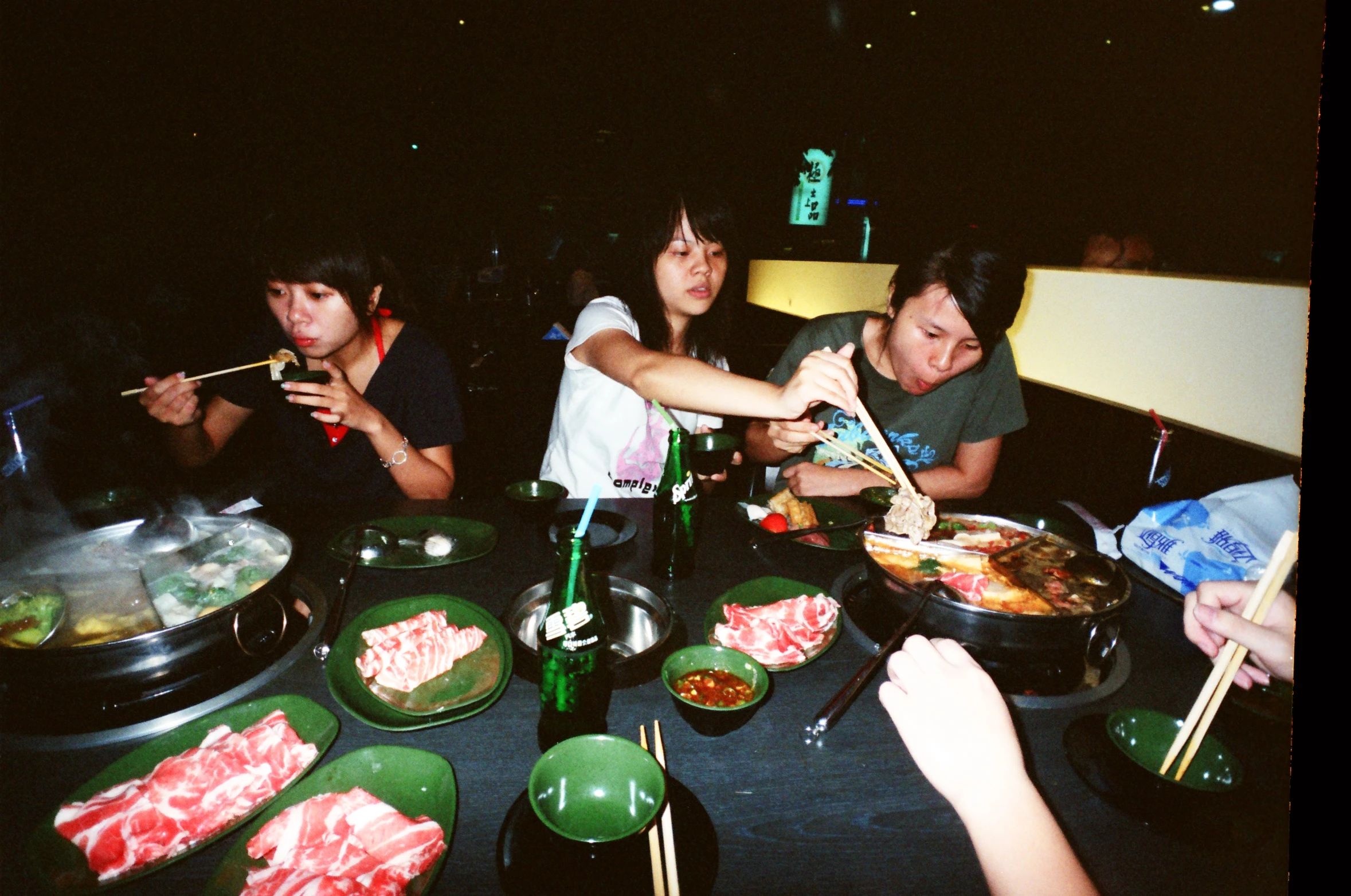 group of people are eating food while sitting at a table